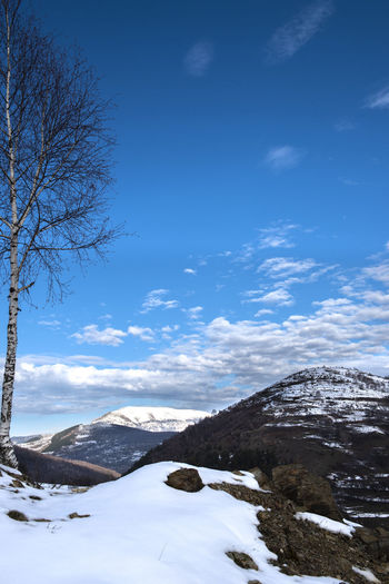 Scenic view of snowcapped mountains against blue sky