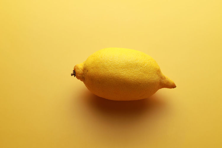 Close-up of lemon slice over yellow background