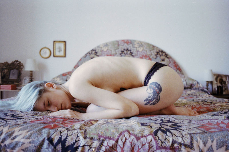 Close-up of young woman lying on bed at home