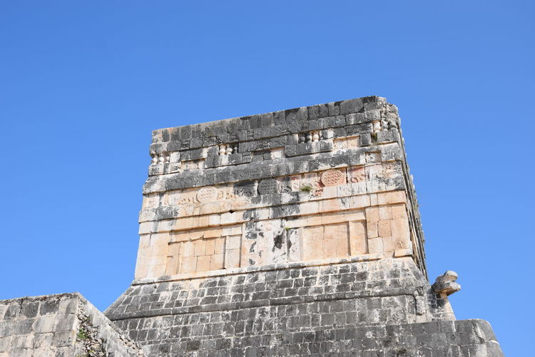Low angle view of old built structure against clear blue sky