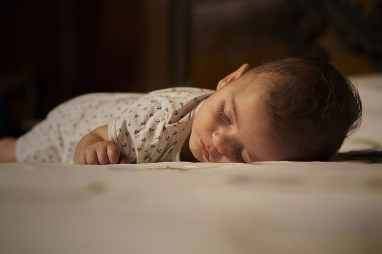Portrait of cute baby sleeping on bed