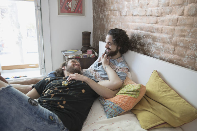 Gay couple lying on their bed together