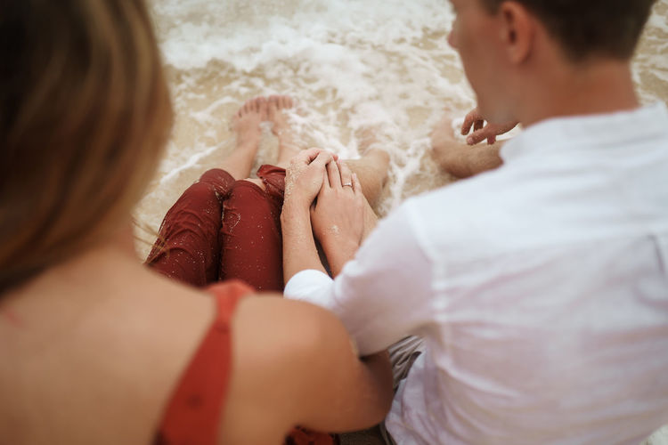 High angle view of young couple sitting at shore