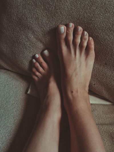 Low section of woman legs on bed