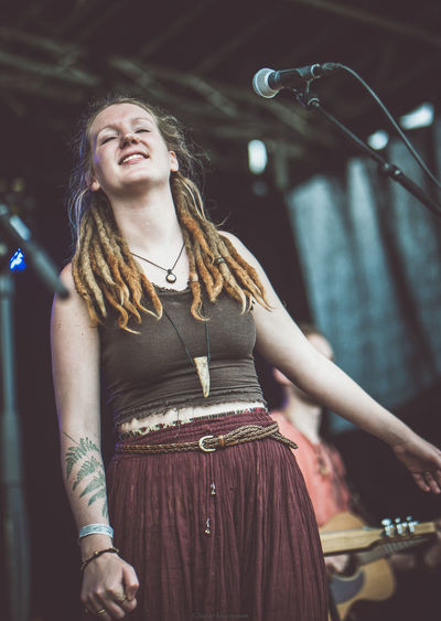 Low angle view of singer with dreadlocks singing on stage