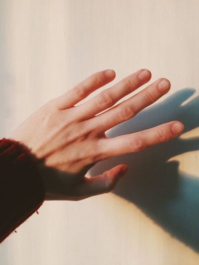 Close-up of hand touching shadow