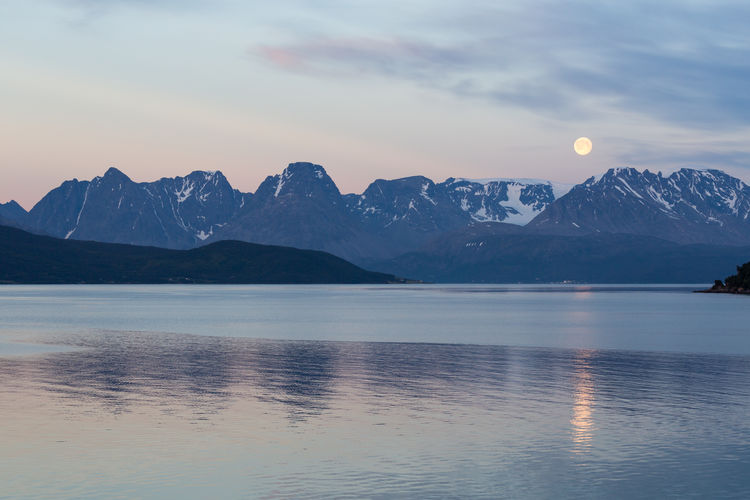Scenic view of sea by lyngen alps against sky at dusk