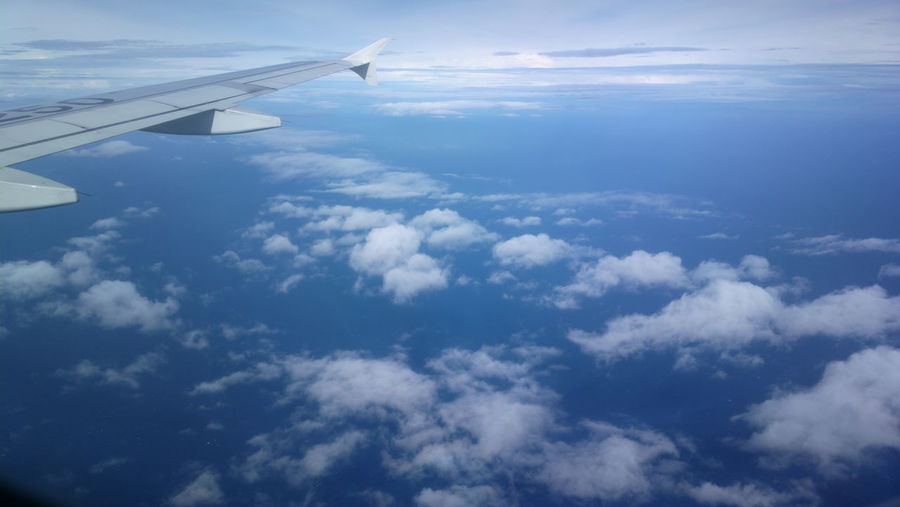 Aerial view of cloudscape over airplane wing
