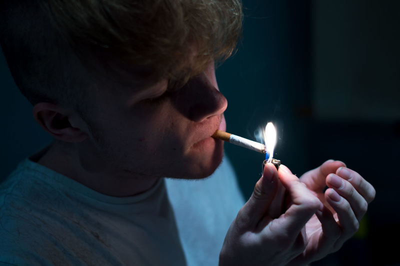 Close-up of man lighting cigarette