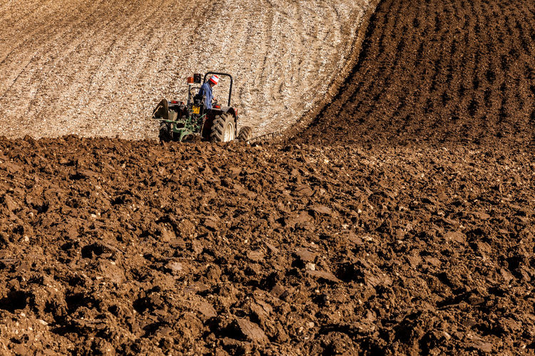 Farm tractor plowing a field in the mountains
