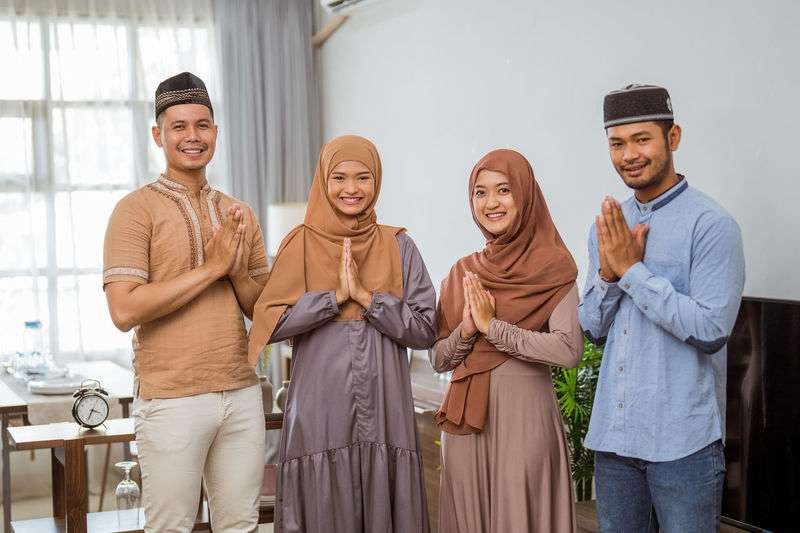 Portrait of smiling family with hands clasped at home