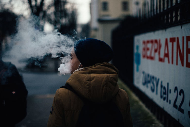 Man smoking sign in city
