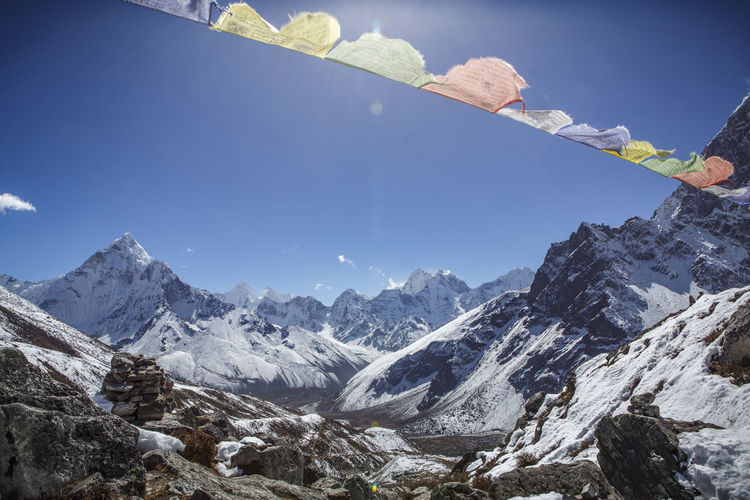 Prayer flags in front of the summit of ama dablam in nepal.