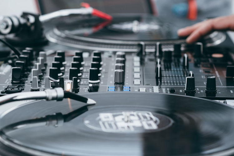 Cropped image of dj mixing music on turntable