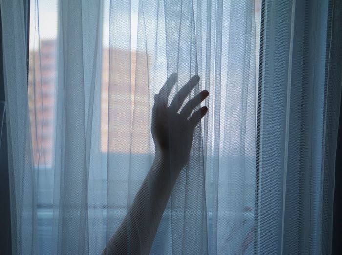 Woman hand silhouette against the window