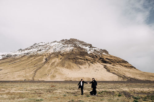 People standing on mountain against sky