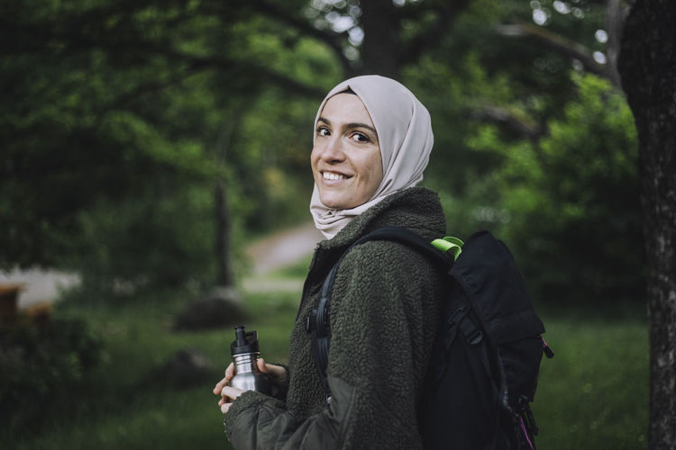 Portrait of smiling woman in hijab hiking on weekend