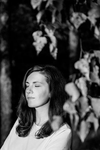 Girl with closed eyes in the forest. bw photo. summer, sunset