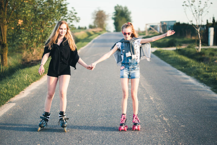 Friends roller skating on road