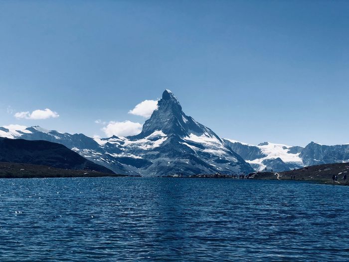 Scenic view of snowcapped mountains against blue sky