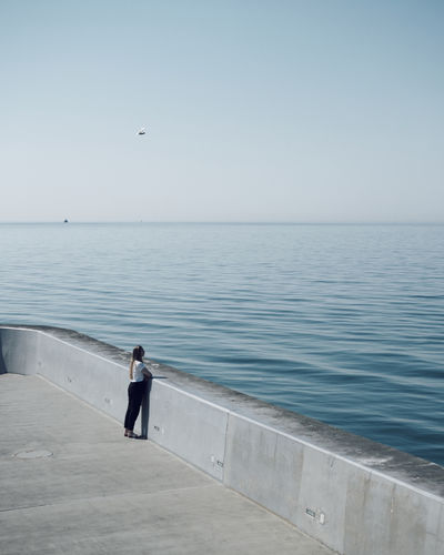 Man looking at sea against clear sky