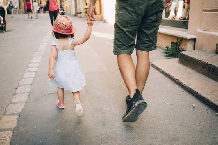 France, aix-en-provence, toddler girl and father walking hand in hand in the city
