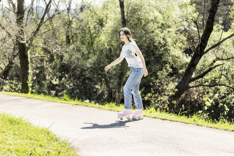 Woman skating in a park with pink roller skates