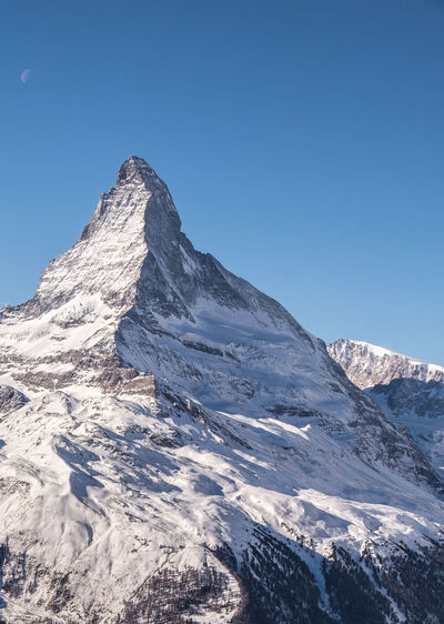 Scenic view of mountains against blue sky