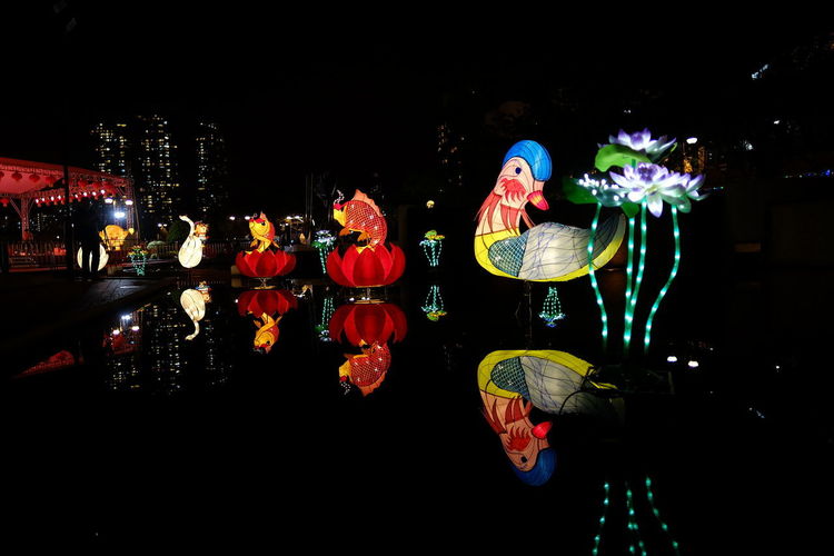 Reflection of illuminated lantern in water at night
