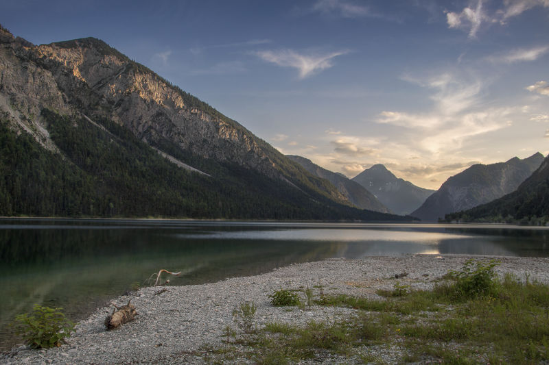 Scenic view of lake by mountains against sky