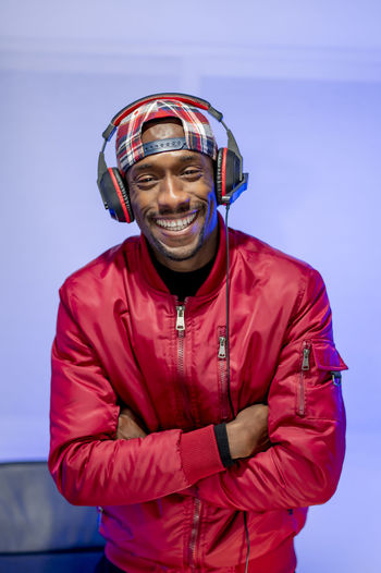 Smiling male influencer with arms crossed standing in studio