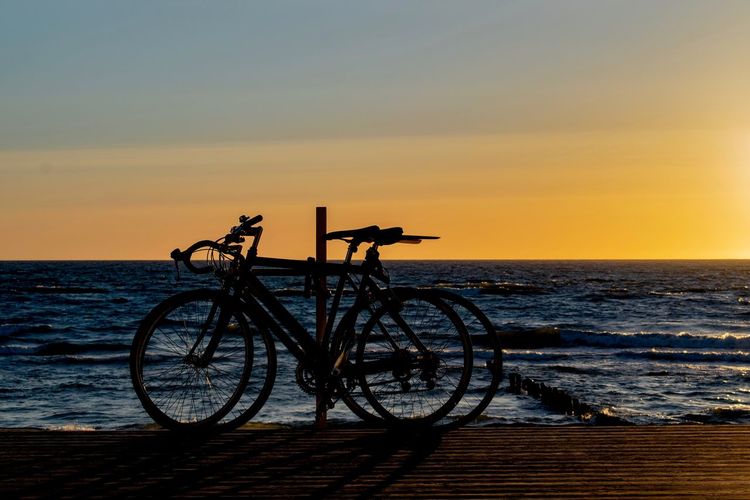 Bicycle silhouettes during sunset at the beach near nida, lithuania