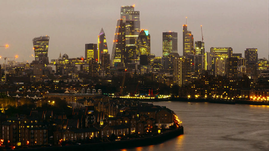 Illuminated buildings in city against sky at night