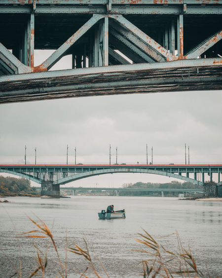 Fishing on a small boat  on vistula river under the poniatowski bridge in warsaw poland