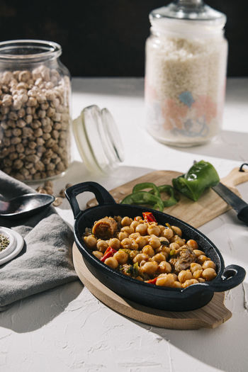 Tasty chickpea stew among ingredients on table