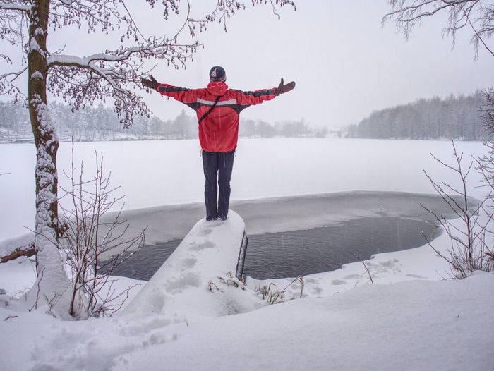 Full length of man standing on frozen lake during winter
