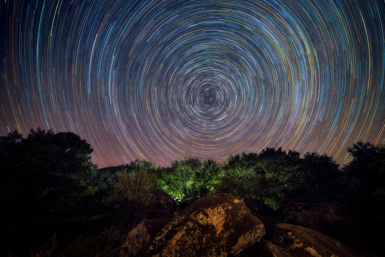 Scenic view of star trail in sky at night