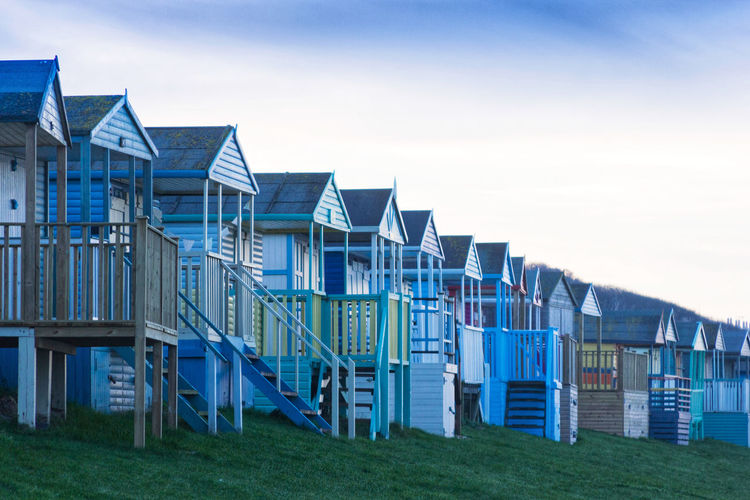 Row of houses on beach against sky