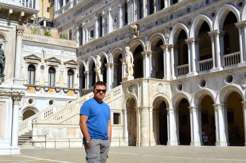 Portrait of man standing in front of historic building