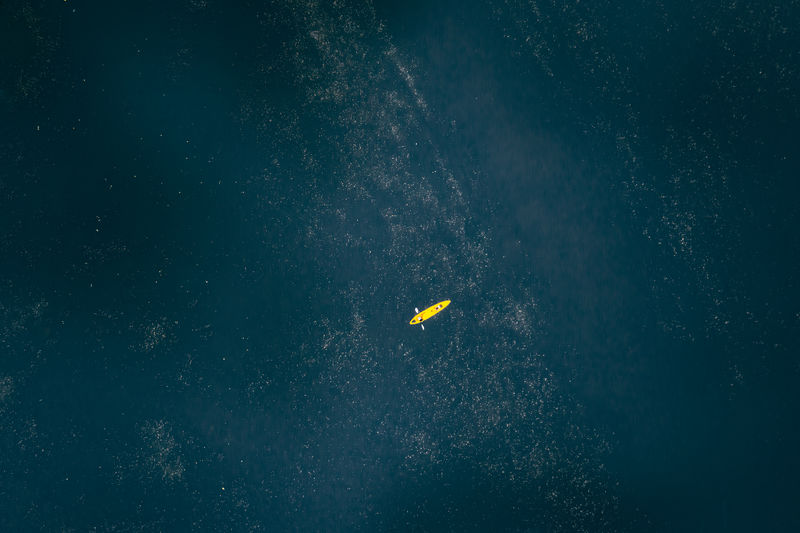 High angle view of yellow kayak floating in the lake, file art photo for background abstrac concept,