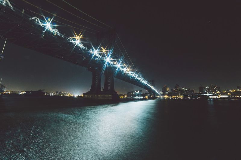 Suspension bridge over river at night