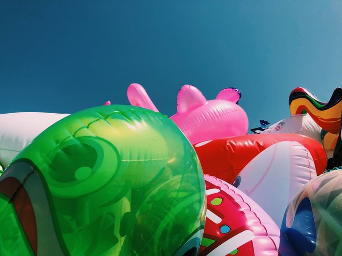 Close-up of multi colored balloons against blue sky