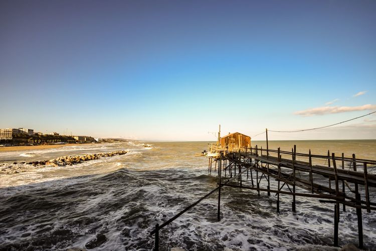 Pier over sea against sky during sunset
