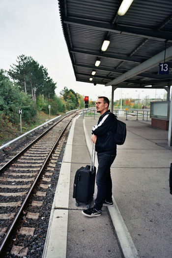 Man standing on railroad station platform