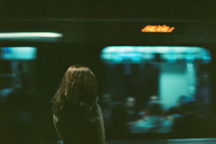 Rear view of woman standing at railroad station platform