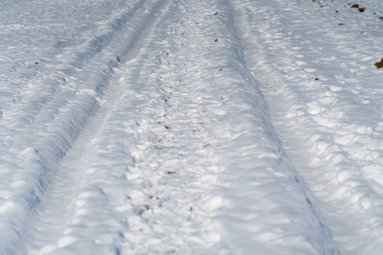 Full frame shot of snow covered tire tracks