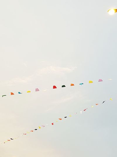 Low angle view of colorful buntings hanging against sky
