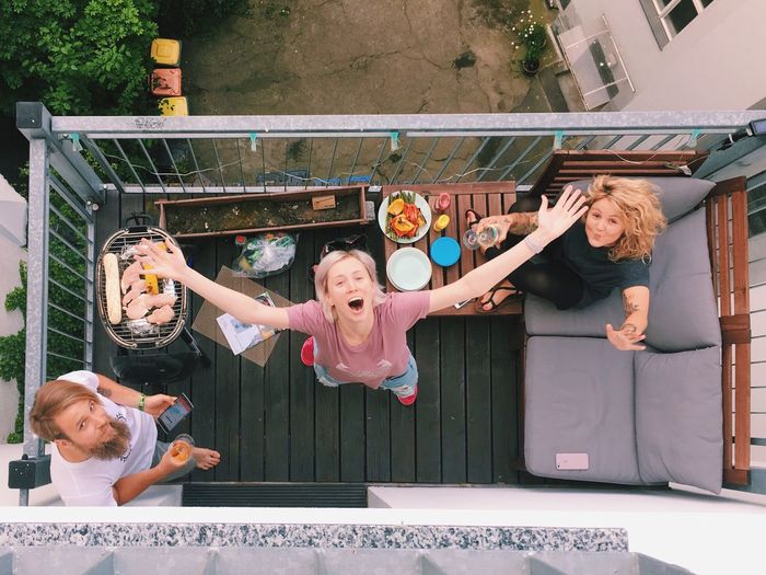 Portrait of happy friends having barbeque party in balcony