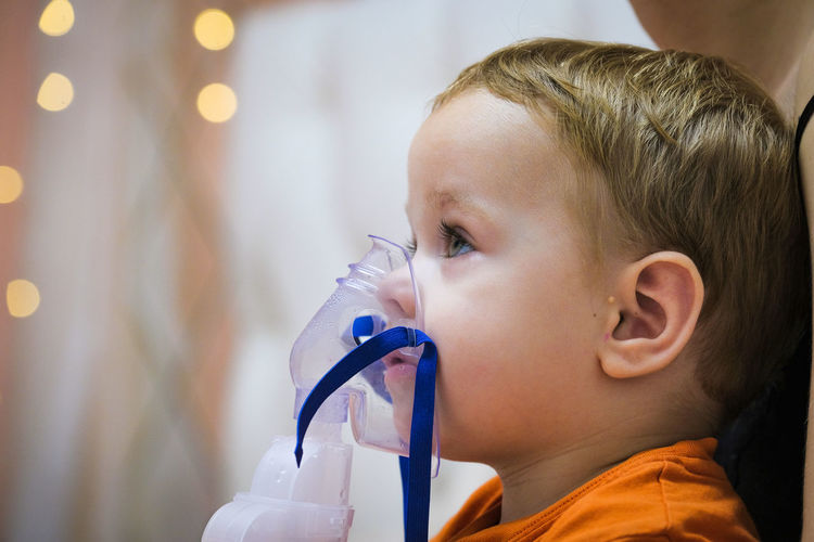 Close-up of baby wearing asthma inhaler
