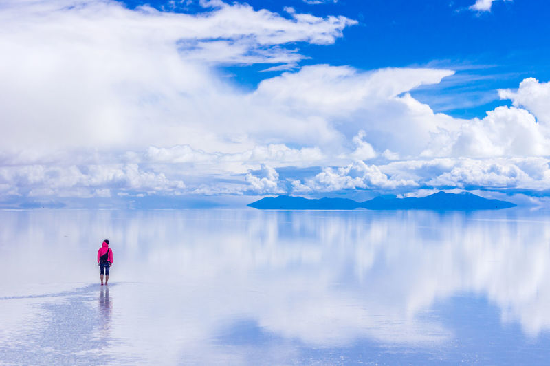 Person standing on salt flat against sky
